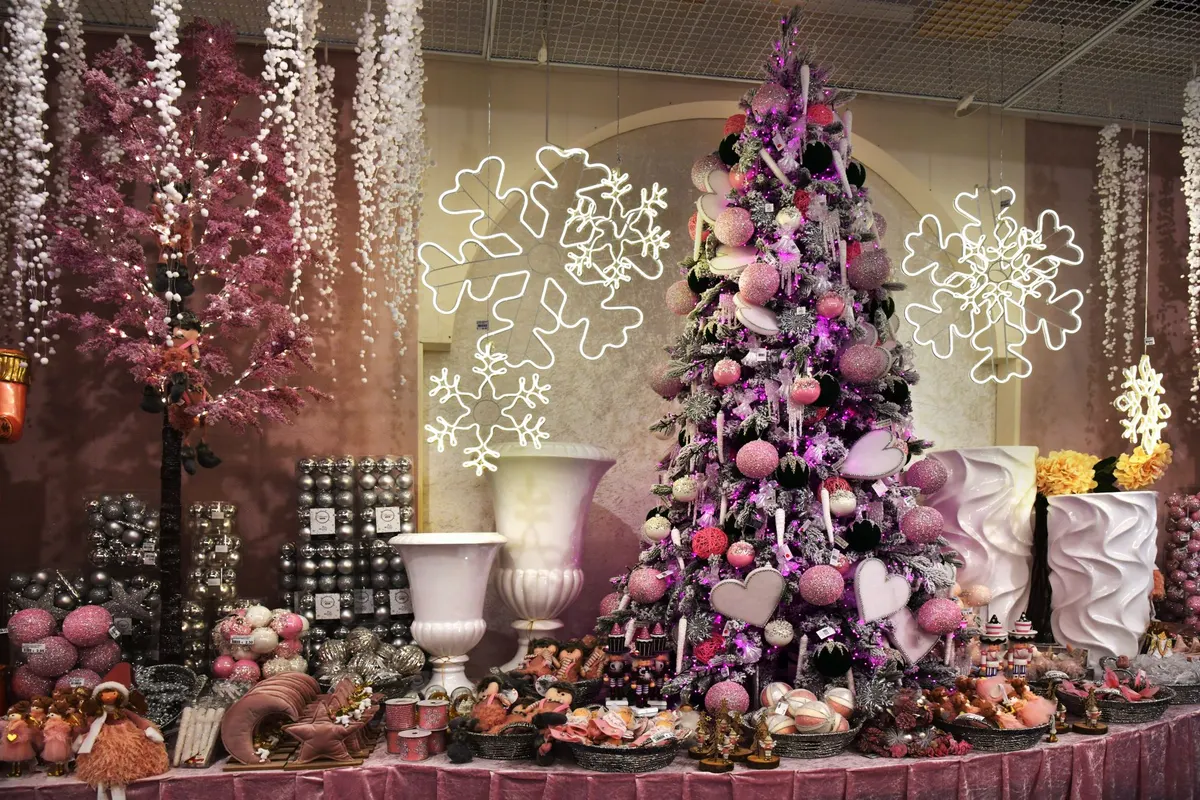 Flocked tree with pink, blush, white and silver ornaments, large pale pink hearts and silver icicles, lit pink-purple