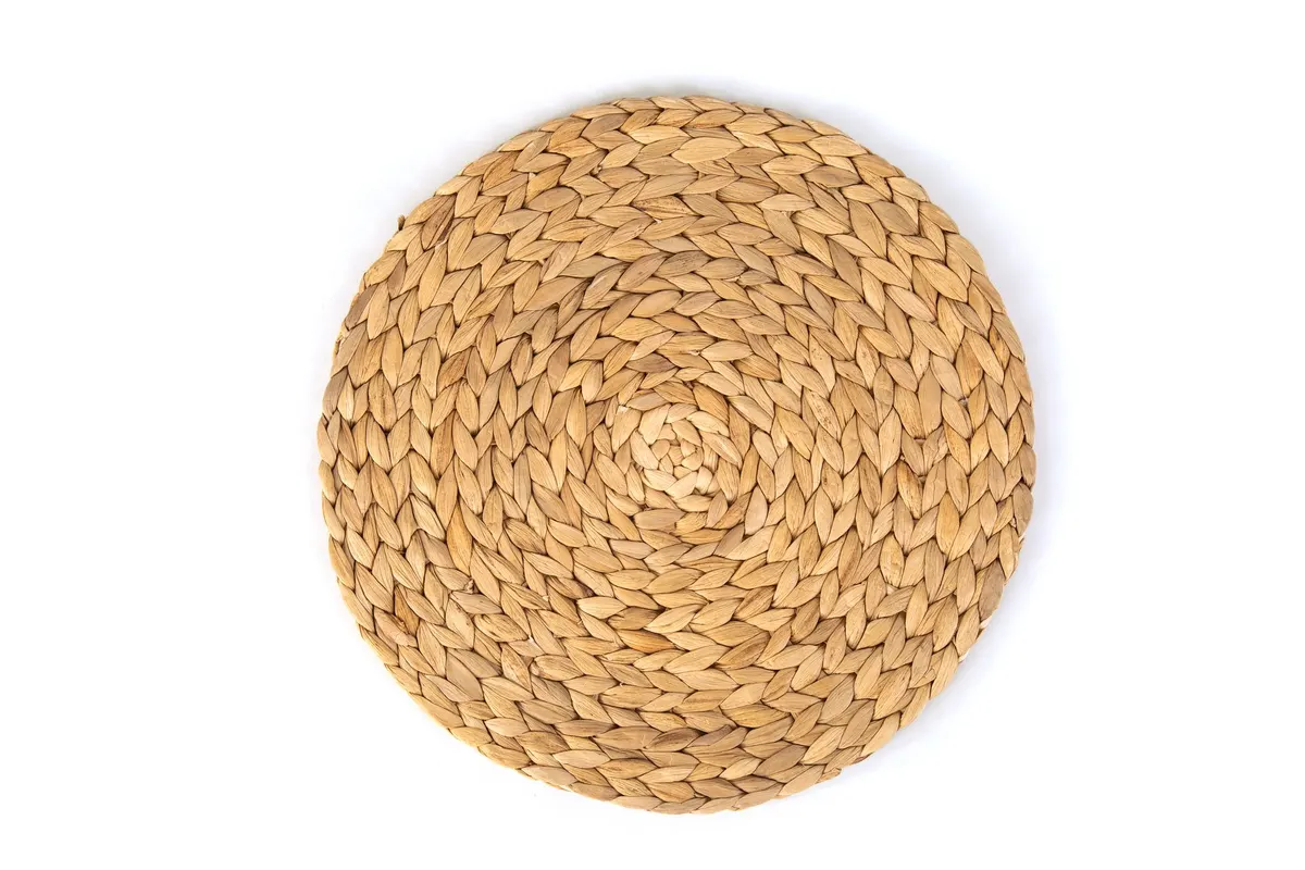 Round honey-tan woven mat with braided rows spiraling out from the center on a white background