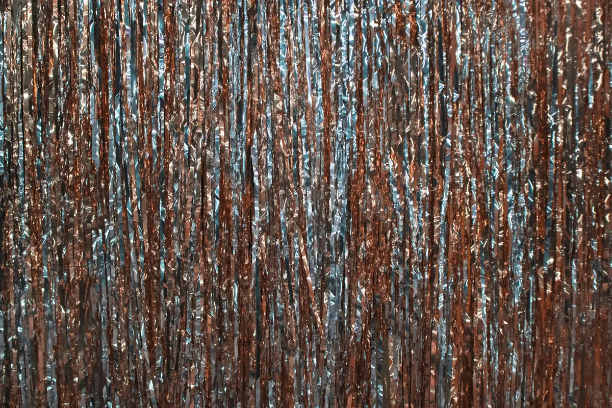 Close view of a silver and copper metallic fringe curtain catching light