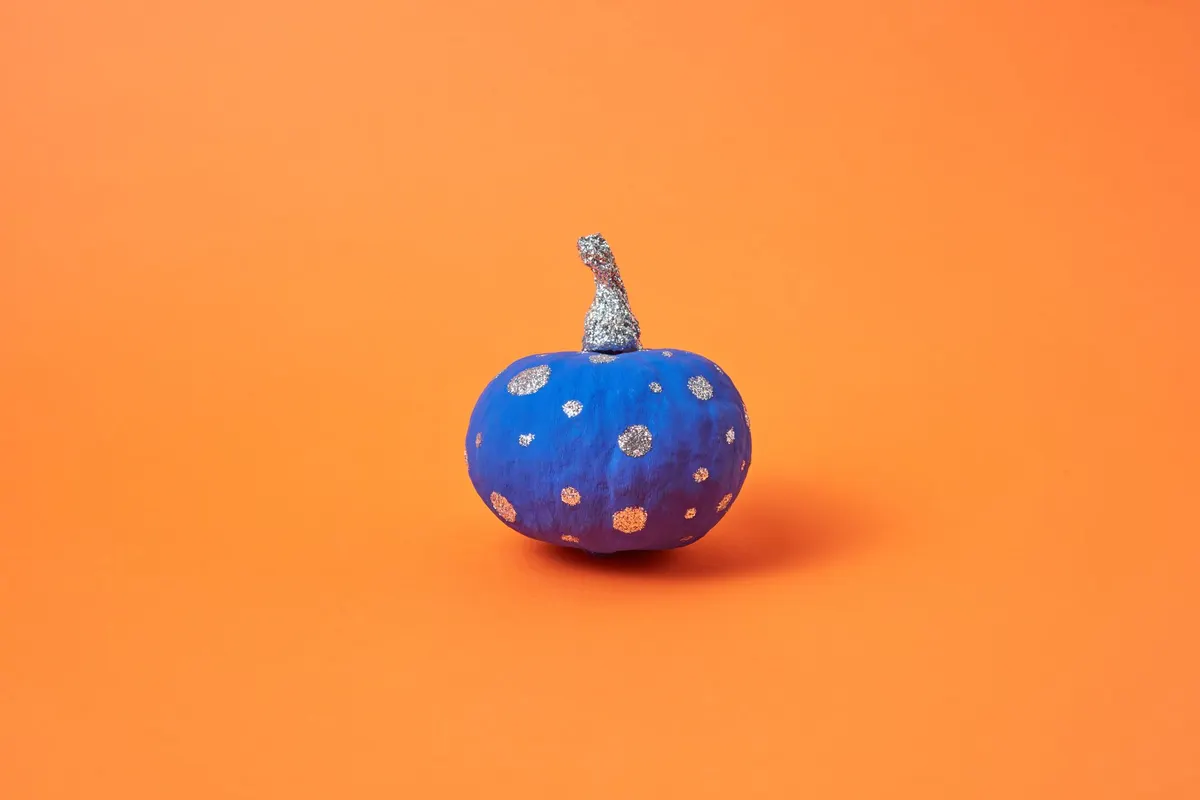 Blue pumpkin shading to purple with scattered silver and gold glitter polka dots and a silver glitter stem
